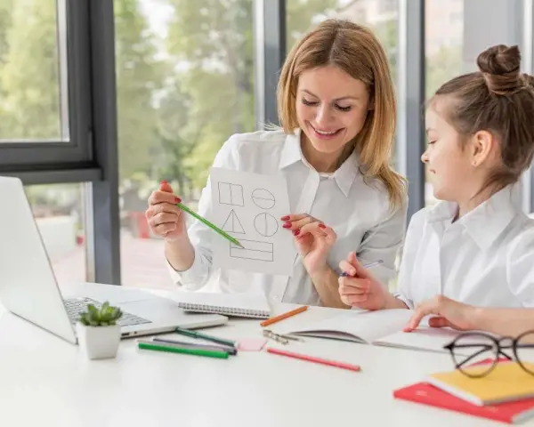 Educatrice mostra forme geometriche a una bambina, un'immagine che evoca offerte lavoro educatore e apprendimento.