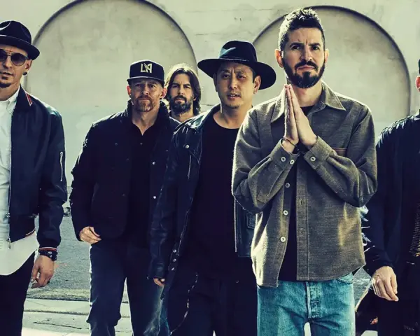 Sechs Männer der Band Linkin Park stehen nebeneinander, einige tragen Hüte und Jacken.