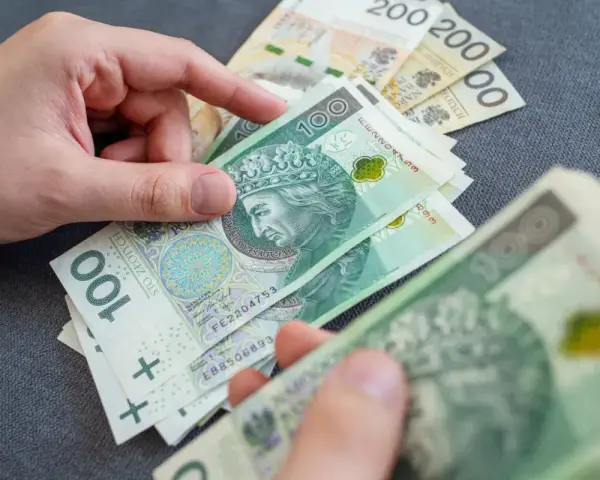 Dłonie liczą polskie banknoty 100 zł. Temat: zespół Aspergera a renta socjalna.