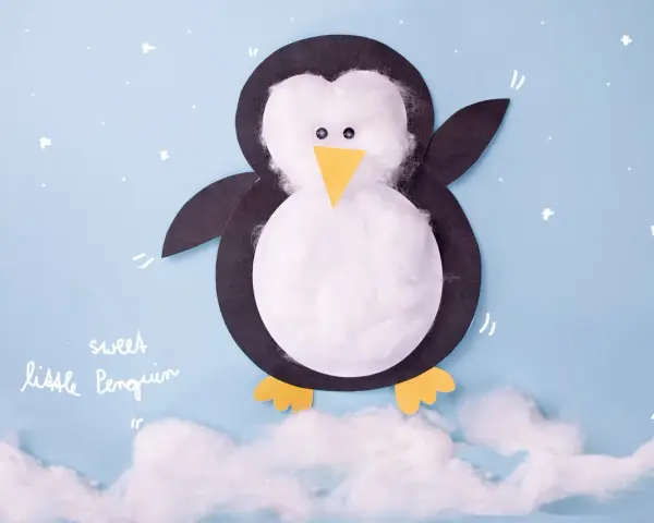 Ein süßer kleiner Pinguin, gebastelt aus Papier und Watte, steht auf Wolken.
