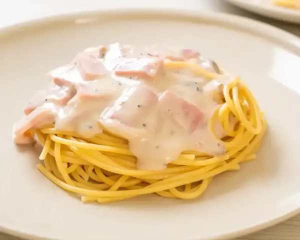 Pyszne spaghetti z kremowym sosem, kawałkami szynki i pieprzem. Idealne makaron po toskańsku na szybki obiad.