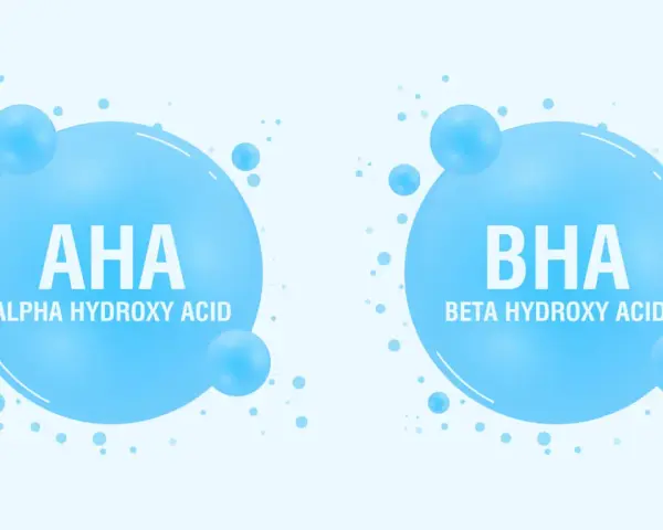 Dwa bąbelki z napisem AHA (Alpha Hydroxy Acid) i BHA (Beta Hydroxy Acid), symbolizujące składniki kosmetyków.