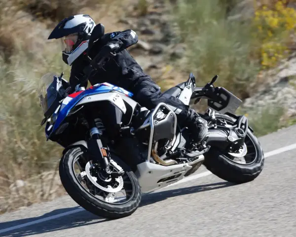 Motociclista in sella a una BMW GS 1300, che affronta una curva su strada sterrata, sfiorando la velocità massima.