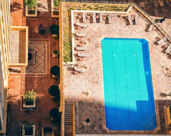 Widok z góry na basen i dziedziniec hotelowy. Idealne miejsce na wakacje all inclusive soft.