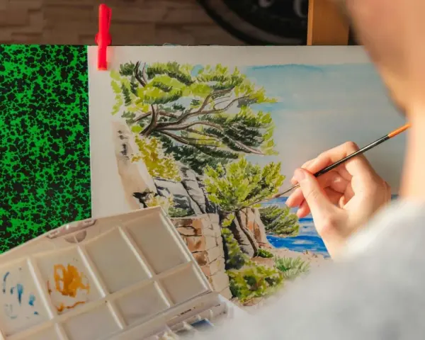 Une main peint un paysage marin, une excellente idée peinture facile pour capturer la beauté de la nature.