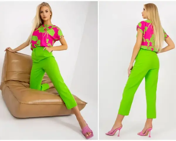 Modelka prezentuje stylizację: jaka bluzka do zielonych spodni? Neonowe spodnie i fuksjowa bluzka z zielonym wzorem.