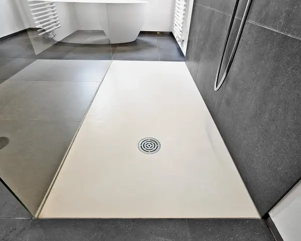 Receveur de douche blanc, quelle matière choisir pour un style moderne ? Sol gris, paroi sombre.