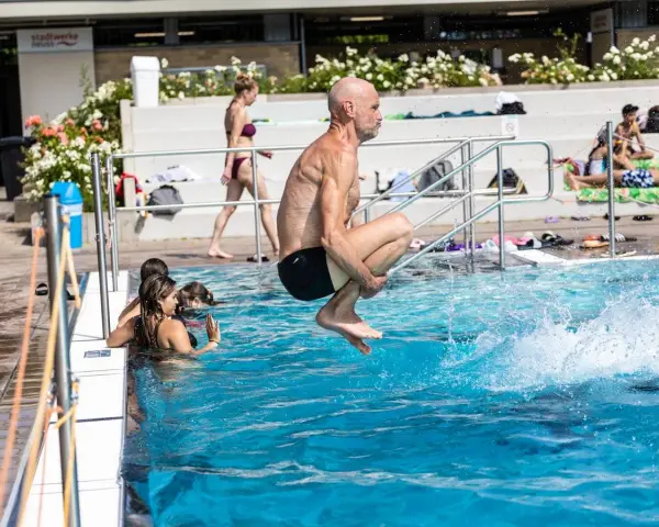 Mann springt ins Wasser, um Thrombose vorzubeugen. Schwimmen ist gut für die Durchblutung.