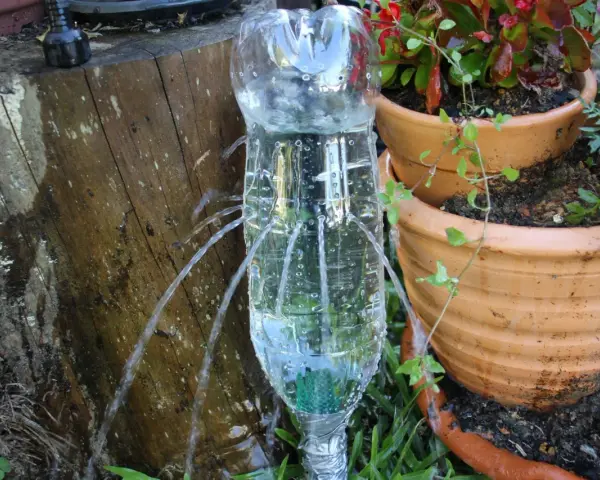 Ingegnosa irrigazione a goccia senza corrente con bottiglie di plastica, che forniscono acqua alle piante in vaso.