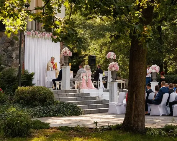 Piękna ceremonia ślubna w plenerze. Czy ksiądz może udzielić ślubu w plenerze? Tak, jak widać na zdjęciu, gdzie młoda para ślubuje sobie miłość przed ołtarzem na świeżym powietrzu.