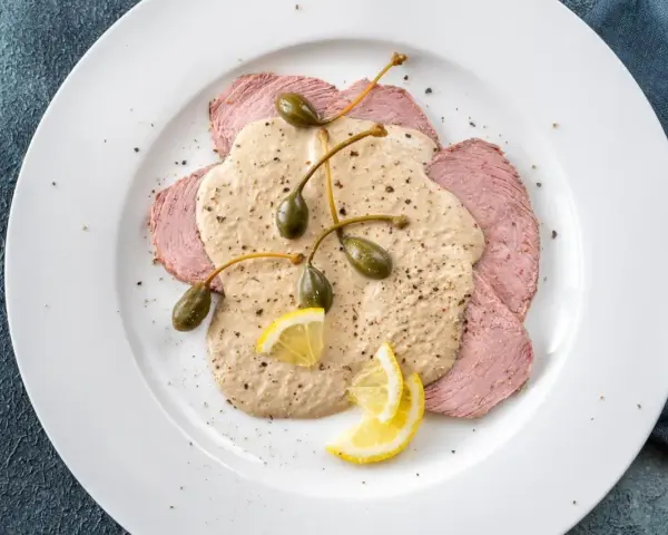 Dünne Scheiben Kalbfleisch mit cremiger Thunfischsauce, Kapern und Zitronenspalten – das beste Vitello Tonnato Rezept für einen Genussmoment.