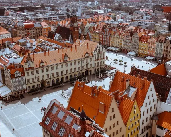 Widok z góry na Rynek we Wrocławiu z kolorowymi kamienicami i ratuszem.