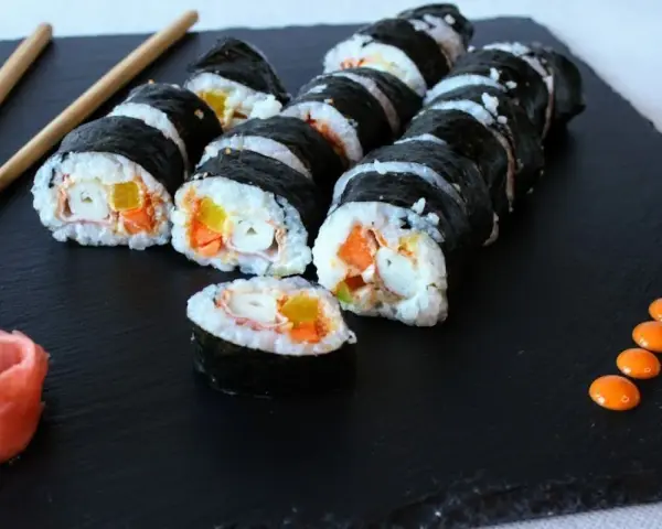 Roladki sushi z surimi, marchewką i papryką. Czy surimi jest zdrowe? Zależy od składu i sposobu przygotowania.