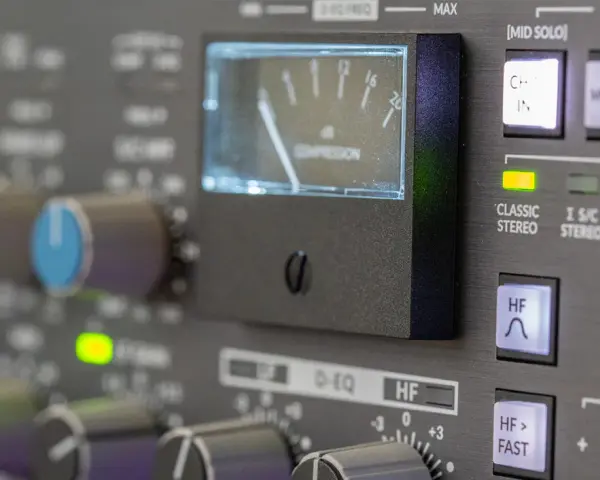 Regler und VU-Meter eines Mischpults, das die analoge Welt der Musikproduktion zeigt.