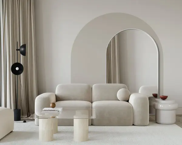 Nowoczesny salon z beżową kanapą, łukiem nad lustrem i stolikiem kawowym. Inspiracja, jak zrobić łuk w aranżacji wnętrz.