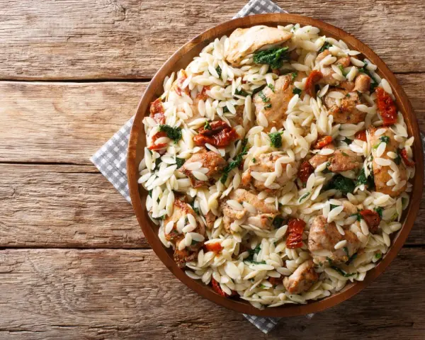 Pyszne danie z makaronem orzo, kurczakiem i suszonymi pomidorami. Idealne, gdy zastanawiasz się, jak gotować makaron orzo.