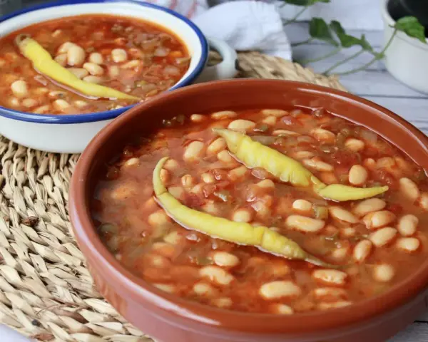 Dos cuencos de pochas a la navarra, un plato reconfortante con judías blancas, tomate y pimientos.