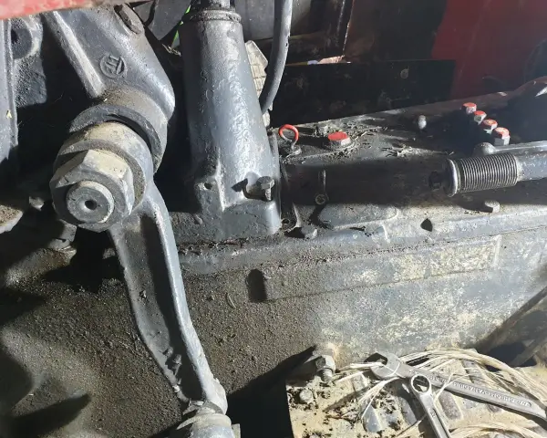 Elementy mechaniczne ciągnika Ursus C-360 podczas remontu skrzyni biegów. Widać ślady oleju i narzędzia.