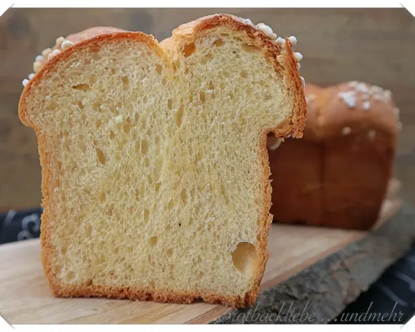 Schnitt von einem goldbraunen Brioche-Brot, perfekt für Lievito Madre Rezepte. Die weiche Krume mit kleinen Luftlöchern und die süße Kruste laden zum Genuss ein.