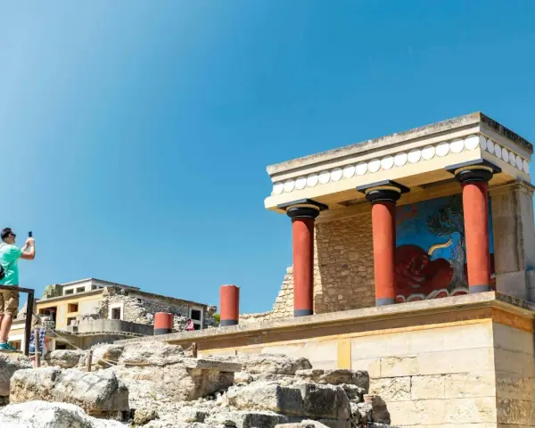 Zwiedzający robi zdjęcie fresku z bykiem w starożytnym pałacu w Knossos.