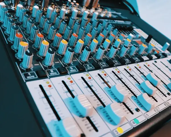 Console de mixage audio avec de nombreux boutons et curseurs. Les niveaux de volume peuvent être ajustés pour un son parfait, peut-être jusqu'à 40 décibels.
