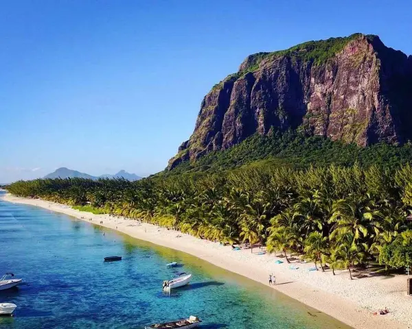 Mauritius pogoda sierpień: rajska plaża z palmami, turkusowa woda i majestatyczna góra Le Morne. Idealne warunki na wakacje.