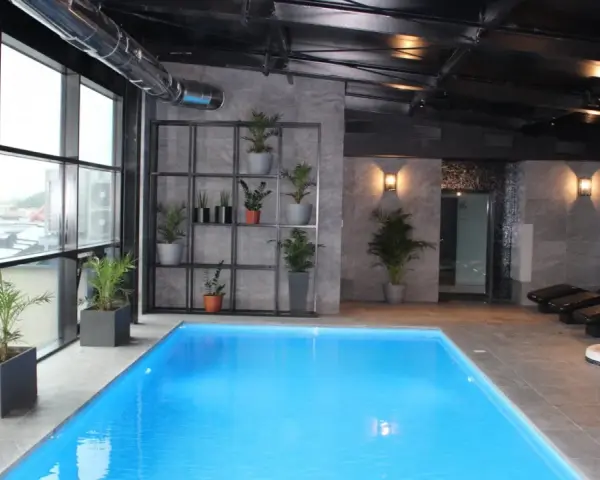 Nowoczesny hotel spa Białystok z basenem, jacuzzi i leżakami. Duże okna z widokiem na miasto.