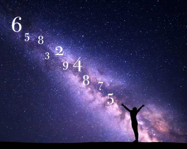 Sylwetka człowieka wita nowy rok astrologiczny pod rozgwieżdżonym niebem. Liczby unoszą się w Drodze Mlecznej.