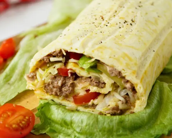 Herzhafte Big Mac Rolle gefüllt mit Hackfleisch, Salat, Tomaten und Käse, serviert auf knackigem Salatblatt.
