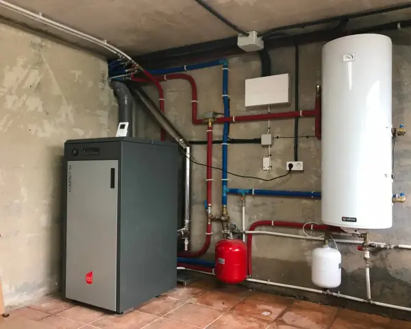 Instalación de caldera de pellets para radiadores, con depósito de agua caliente y sistema de tuberías.