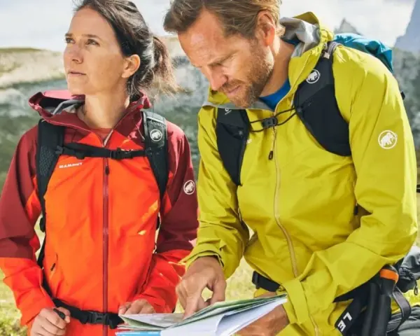 Wanderer prüfen die Route. Ihre wasserdichten Jacken schützen sie vor dem Wetter.