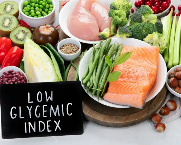 Łosoś, kurczak, warzywa, owoce i orzechy na tle tabliczki z napisem "Low Glycemic Index".
