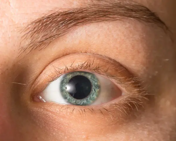 Occhio con iride azzurra e pupille dilatate, forse per l'emozione o la poca luce.