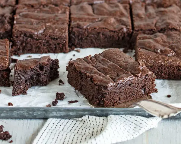 Saftige Schokoladen-Brownies, perfekt für jedes Brownie Rezept. Ein Stück wird gerade herausgehoben.