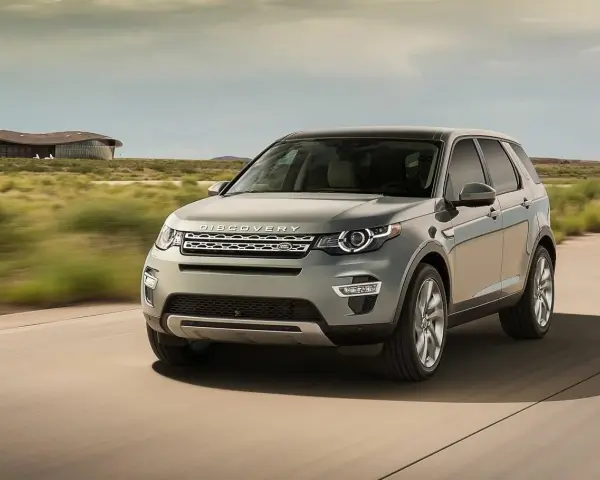 Szary Land Rover Discovery Sport w ruchu, z widocznym napisem "DISCOVERY". Czyżby kolejne awarie?