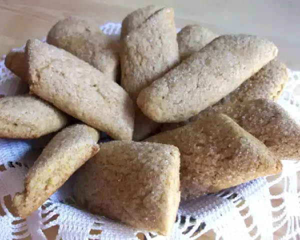 Un cesto pieno di biscotti della nonna, dorati e cosparsi di zucchero, invitano a un assaggio di dolcezza casalinga.