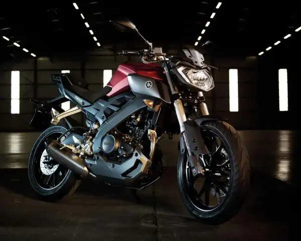 Czerwono-szary motocykl Yamaha TZR 125 V-Max w ciemnym pomieszczeniu.