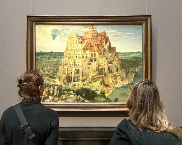 Dwie osoby oglądają obraz Wieża Babel w Muzeum Historii Sztuki w Wiedniu.