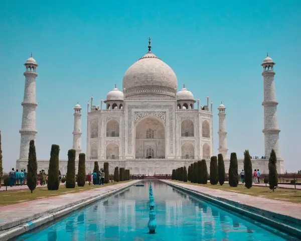 El Taj Mahal, en Agra, India, se alza majestuoso con su cúpula blanca y minaretes, reflejado en el estanque.