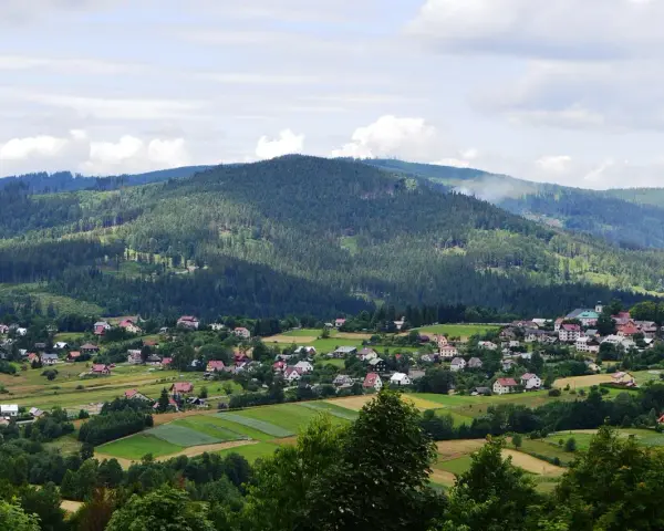 Letnia panorama Istebnej z górami i domkami. Idealne miejsce na wakacje, pełne atrakcji.