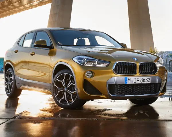 Złoty BMW X2 na tle mostu i skateparku. Nowoczesny leasing jak abonament, bez zobowiązań.