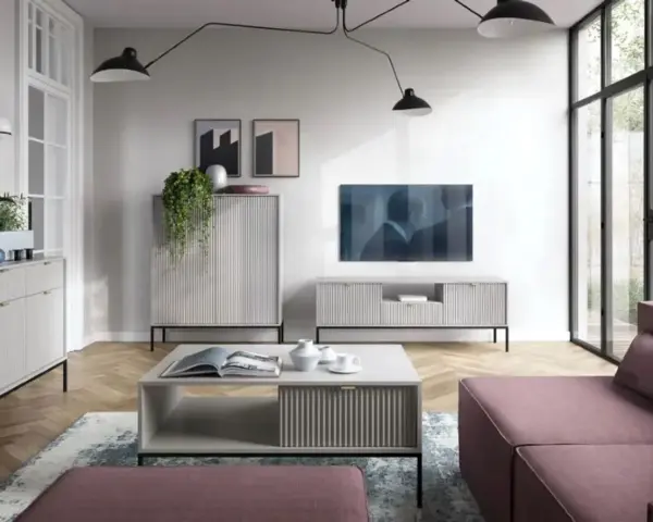 Nowoczesny salon z dużą **ścianą TV**, minimalistycznymi meblami i wygodną, różową sofą.