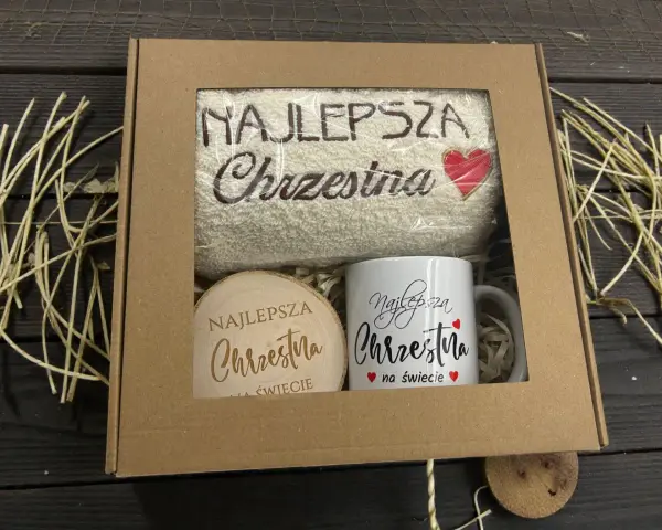 Prezent dla najlepszej chrzestnej: ręcznik z haftem i kubek z napisem "Najlepsza Chrzestna na świecie".