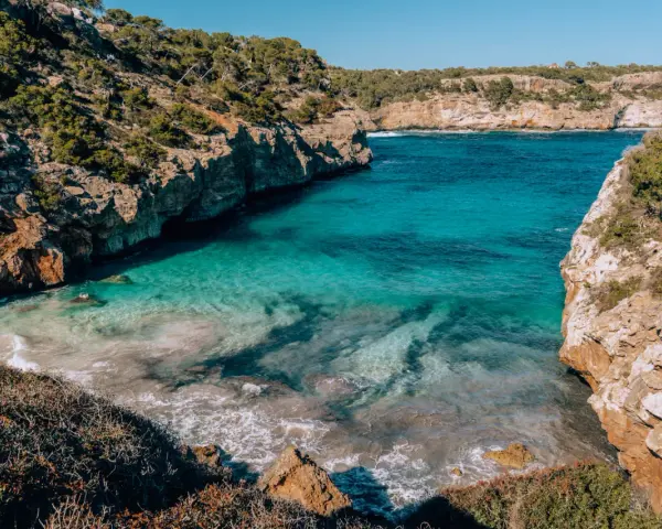 Cala des Moro, Majorka. Turkusowa woda obmywa skaliste wybrzeże, tworząc malowniczą zatoczkę.