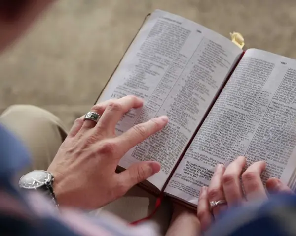 Dłonie pary przeglądają Biblię, szukając pocieszenia i siły przeciwko złemu duchowi.