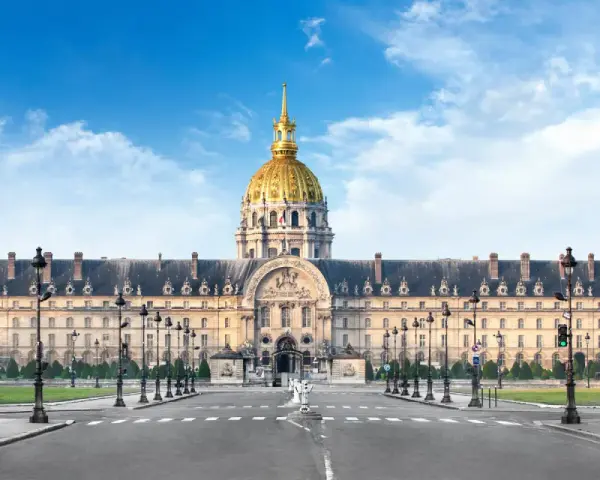 Imponente cúpula dorada del Hôtel des Invalides en París, con su fachada clásica y farolas a ambos lados de la avenida.