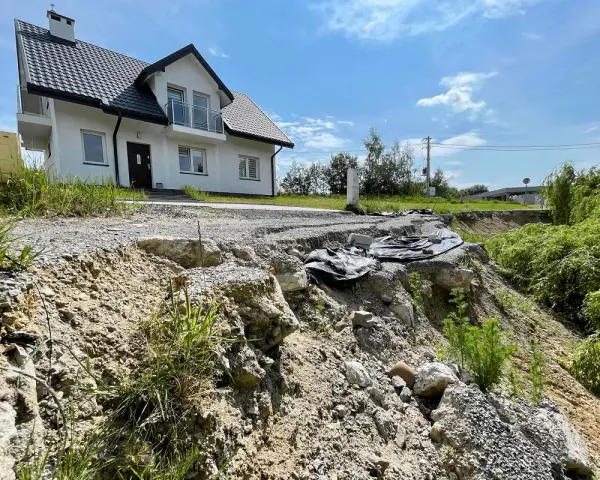 Nieaktywne osuwisko obok budowy domu. Teren niestabilny, droga częściowo zniszczona.