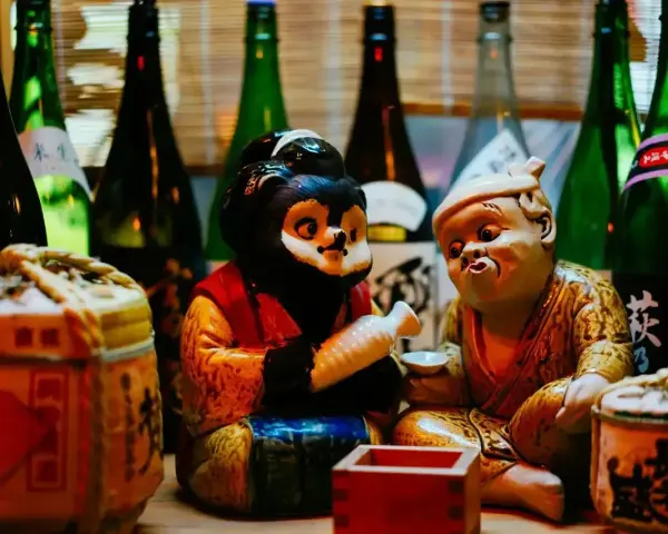 Figurki tanuki i starca z sake. Dowiedz się, jak pić sake, by poczuć japoński klimat.