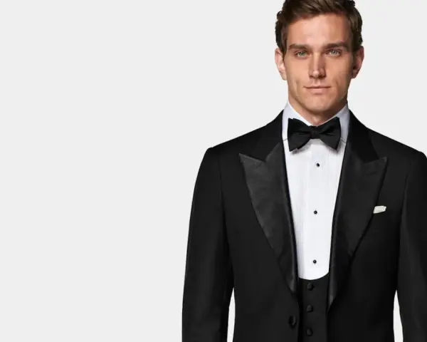 Elegancki mężczyzna w czarnym smokingu, idealny na wydarzenia z kodem **black tie dress code**.