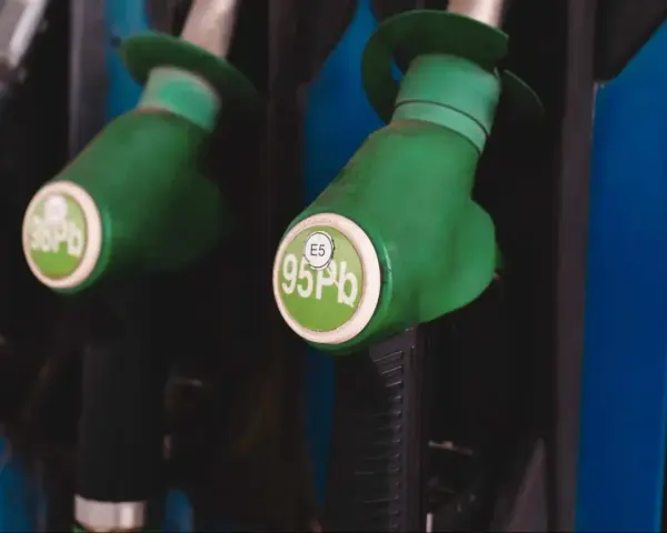 Dwa zielone pistolety dystrybutorów paliwa, jeden z napisem "98 Pb", drugi z "E5 95 Pb". Idealne do tankowania VW Polo 1.2 benzyna.